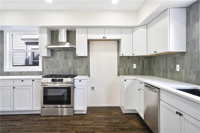 3009 Campbell St, Kansas City, MO 64109 - kitchen featuring tasteful backsplash, wall chimney exhaust hood, light countertops, and appliances with stainless steel finishes
