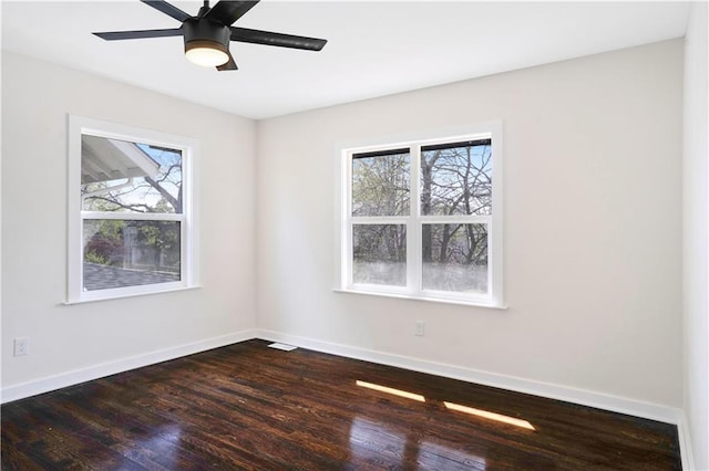 3009 Campbell St, Kansas City, MO 64109 - unfurnished room featuring a healthy amount of sunlight, baseboards, and dark wood-style floors