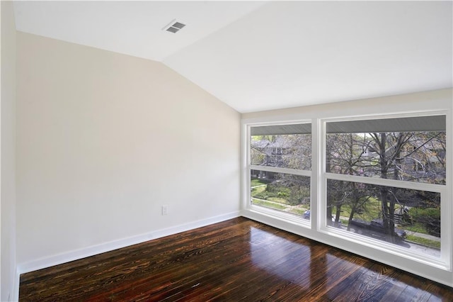 3009 Campbell St, Kansas City, MO 64109 - unfurnished room featuring dark wood-style flooring, baseboards, vaulted ceiling, and visible vents