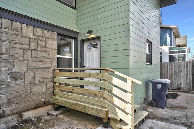 3009 Campbell St, Kansas City, MO 64109 - doorway to property featuring fence and stone siding