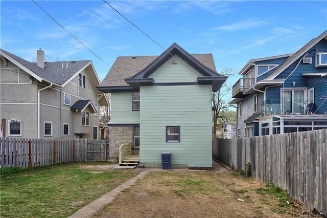 3009 Campbell St, Kansas City, MO 64109 - rear view of property featuring a fenced backyard and a lawn