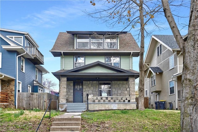 3009 Campbell St, Kansas City, MO 64109 - american foursquare style home with a porch, roof with shingles, fence, and stone siding