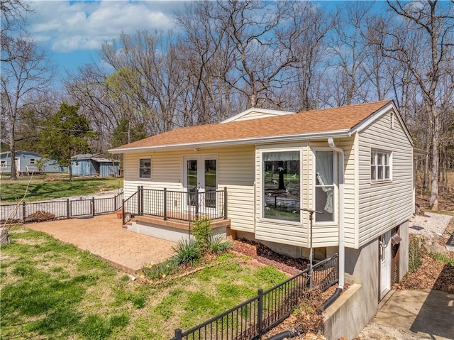 back of property featuring a garage, a lawn, fence, a patio, and french doors