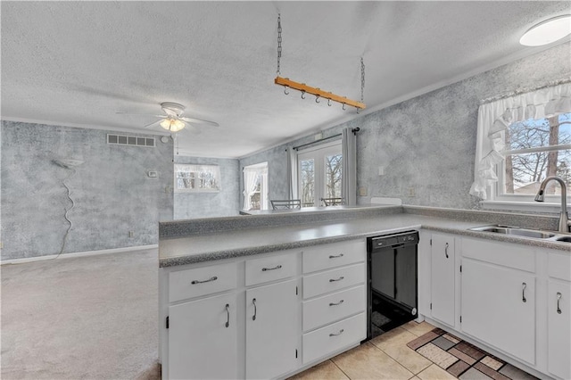 kitchen featuring a textured ceiling, black dishwasher, visible vents, ceiling fan, and a sink