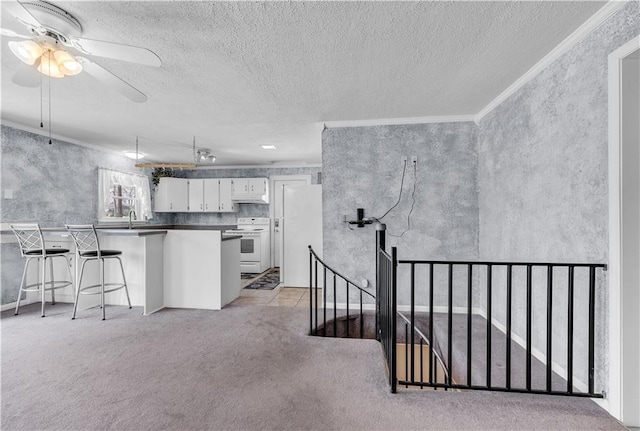 kitchen with crown molding, ceiling fan, white appliances, white cabinets, and dark countertops