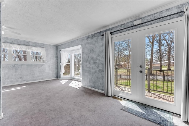 interior space featuring a textured ceiling, french doors, crown molding, and carpet