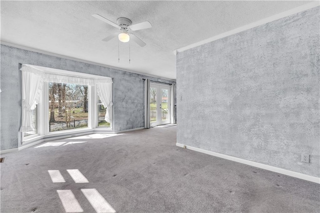 spare room with carpet floors, a textured ceiling, baseboards, and ceiling fan