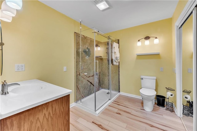 bathroom with visible vents, toilet, a shower stall, and wood finished floors