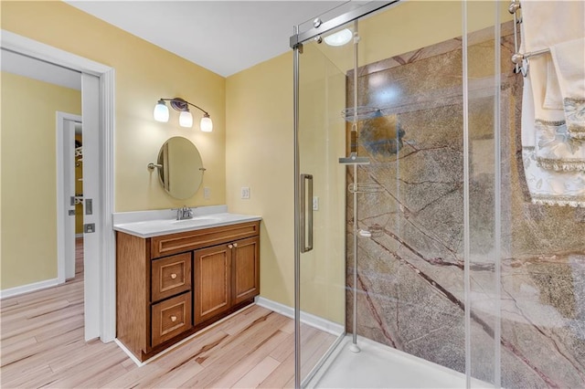 full bathroom with baseboards, a shower stall, vanity, and wood finished floors
