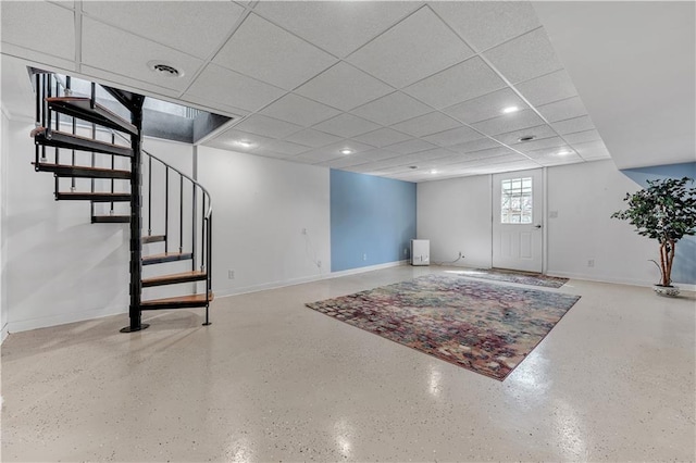 below grade area featuring baseboards, a drop ceiling, visible vents, and stairway
