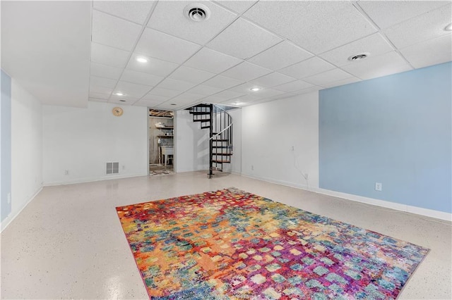finished basement with stairs, visible vents, and baseboards
