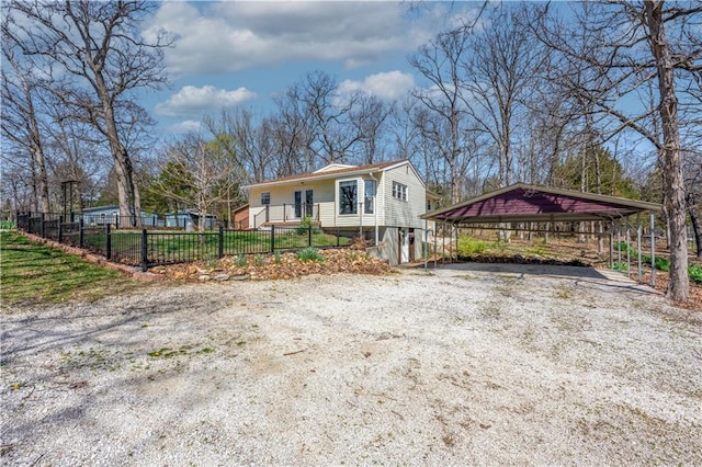 view of front of house with a detached carport, a fenced front yard, and driveway