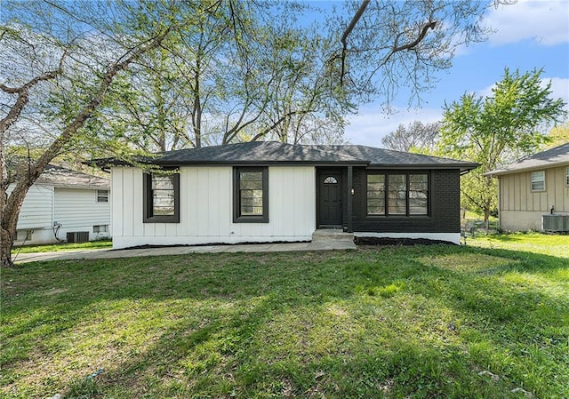 710 N Redwood Dr, Independence, MO 64056 - view of front of house with brick siding, a front yard, and central AC