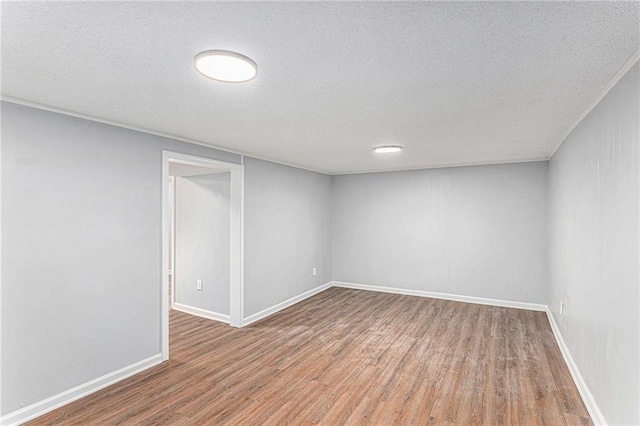 710 N Redwood Dr, Independence, MO 64056 - finished below grade area featuring baseboards, wood finished floors, and a textured ceiling