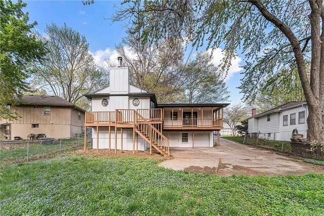 710 N Redwood Dr, Independence, MO 64056 - rear view of property with driveway, a wooden deck, an attached garage, a lawn, and stairs