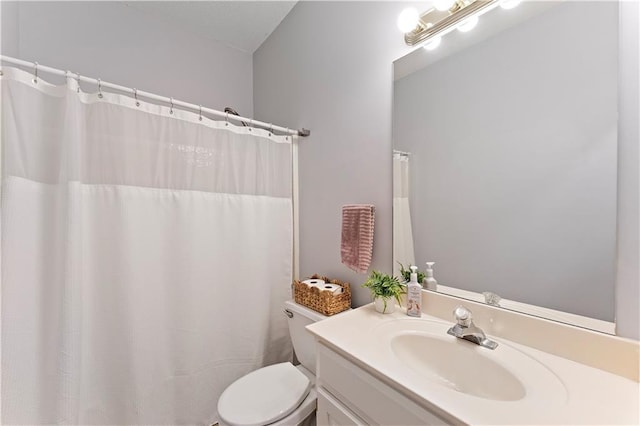 full bathroom featuring toilet, vanity, and a shower with curtain