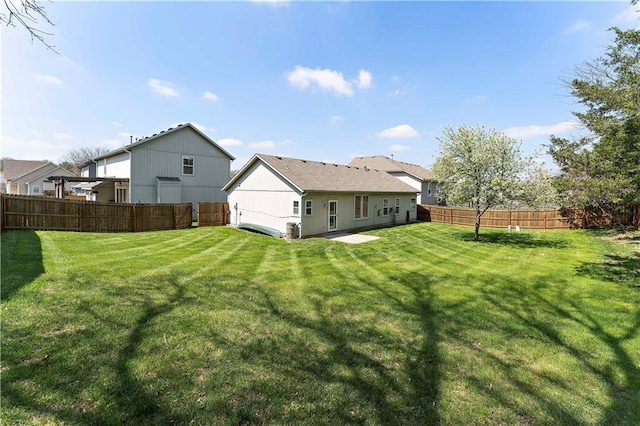 rear view of property with a yard and a fenced backyard