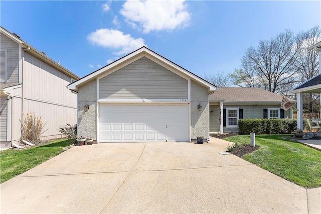 view of front of home featuring concrete driveway, a front lawn, and an attached garage
