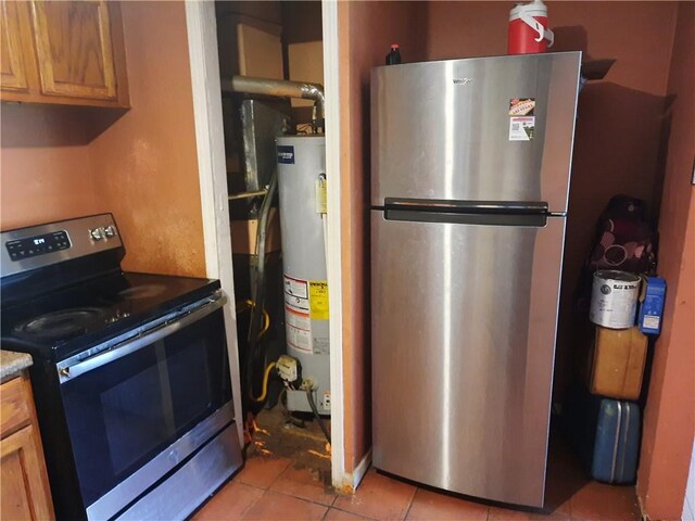 kitchen featuring water heater, light tile patterned floors, brown cabinetry, and stainless steel appliances