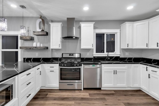 kitchen featuring open shelves, white cabinets, wall chimney exhaust hood, appliances with stainless steel finishes, and a sink