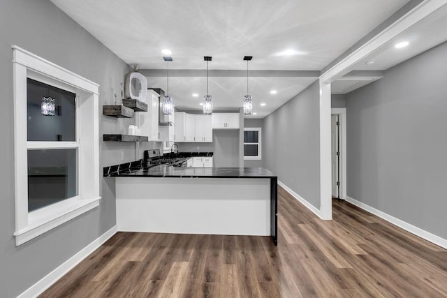 kitchen with white cabinets, a peninsula, baseboards, and dark countertops