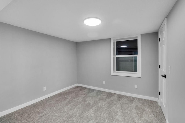 carpeted empty room featuring baseboards