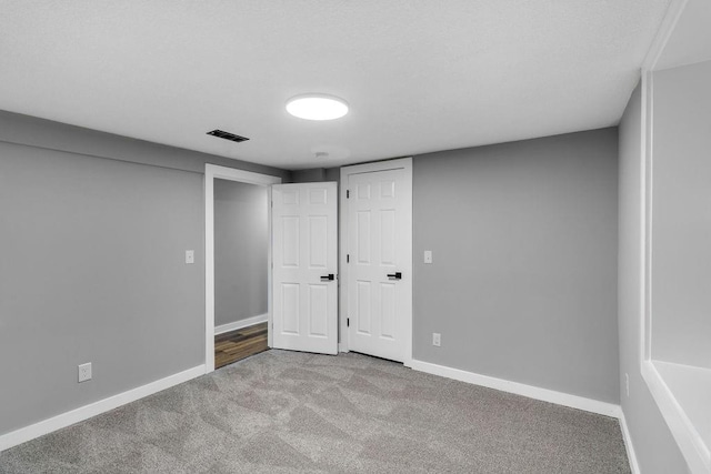 finished below grade area featuring baseboards, visible vents, and carpet floors
