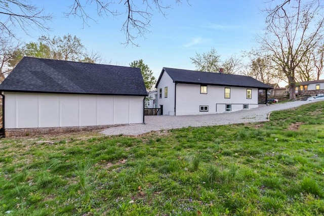 back of property featuring a yard and an outdoor structure