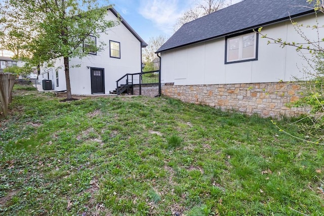 view of yard with central AC and fence