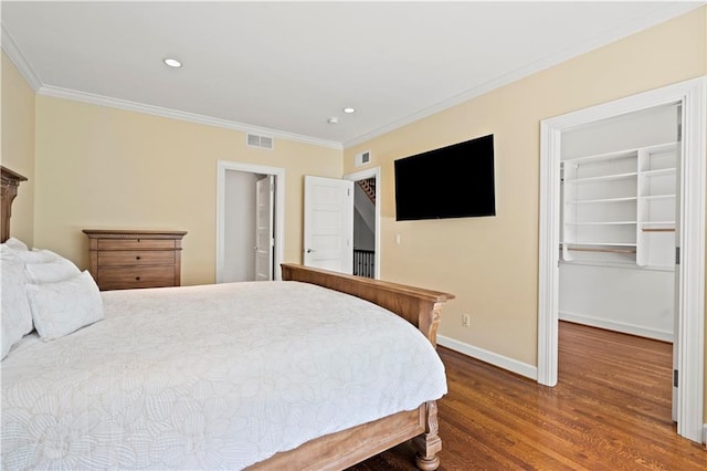 4924 Central St, Kansas City, MO 64112 - bedroom with a walk in closet, ornamental molding, wood finished floors, and visible vents