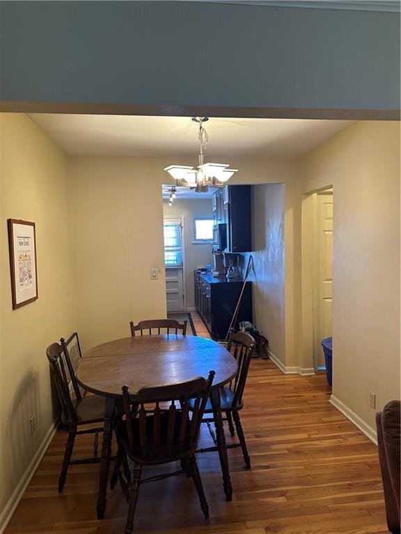 4209 Clark Ave Unit 4209-4, Kansas City, MO 64111 - dining space featuring baseboards, a chandelier, and wood finished floors