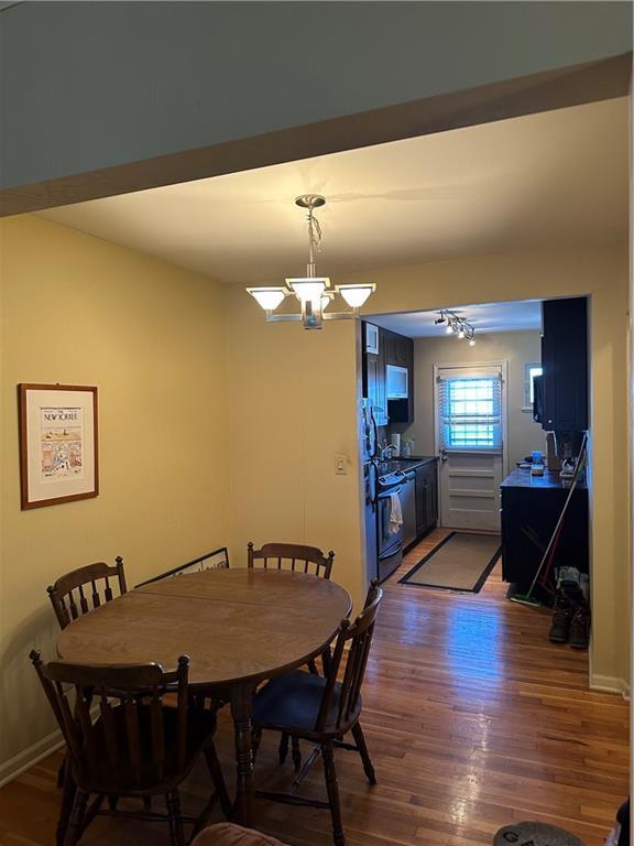 4209 Clark Ave Unit 4209-4, Kansas City, MO 64111 - dining area featuring wood finished floors, an inviting chandelier, and baseboards