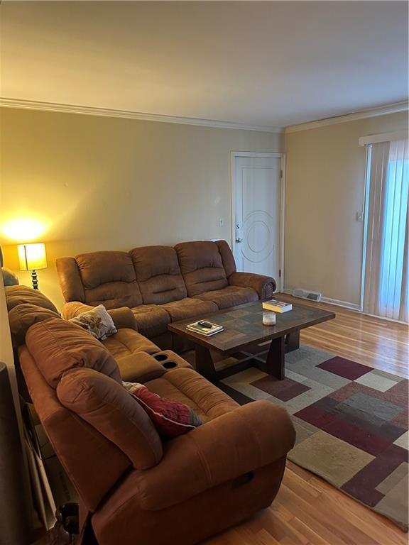 4209 Clark Ave Unit 4209-4, Kansas City, MO 64111 - living room with crown molding, visible vents, and wood finished floors