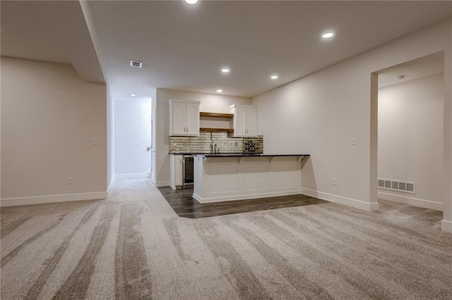 8216 NW 89th Ter, Kansas City, MO 64153 - kitchen featuring visible vents, open floor plan, white cabinetry, and carpet flooring