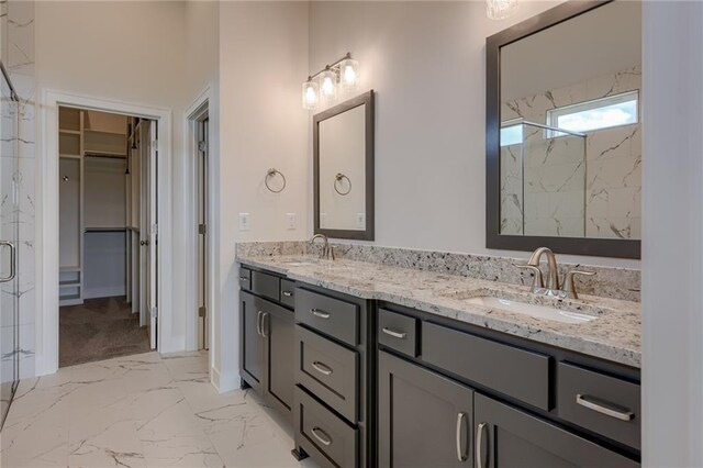 8216 NW 89th Ter, Kansas City, MO 64153 - bathroom featuring double vanity, marble finish floor, a sink, and a spacious closet