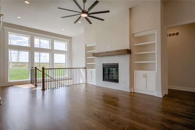 8216 NW 89th Ter, Kansas City, MO 64153 - unfurnished living room featuring ceiling fan, visible vents, wood finished floors, baseboards, and built in shelves