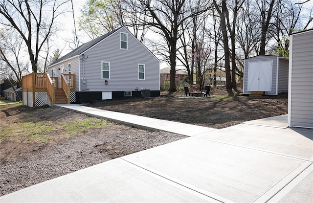 5606 N Indiana Ave, Kansas City, MO 64119 - view of side of home featuring an outdoor structure, a deck, central AC unit, and a shed