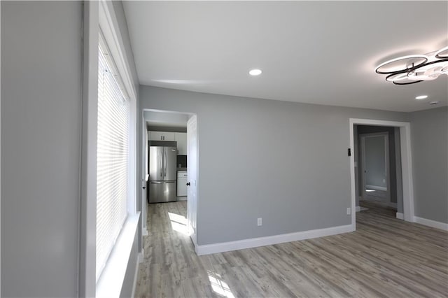 5606 N Indiana Ave, Kansas City, MO 64119 - spare room with an inviting chandelier, recessed lighting, light wood-style flooring, and baseboards