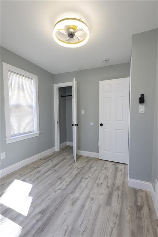 5606 N Indiana Ave, Kansas City, MO 64119 - unfurnished bedroom with light wood-style floors, baseboards, and a closet