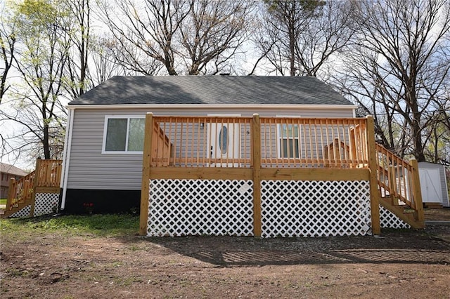 5606 N Indiana Ave, Kansas City, MO 64119 - rear view of house featuring stairs, a shingled roof, and a deck