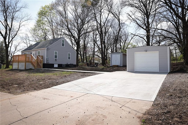 5606 N Indiana Ave, Kansas City, MO 64119 - view of side of home featuring a deck, a storage unit, stairs, an outbuilding, and driveway