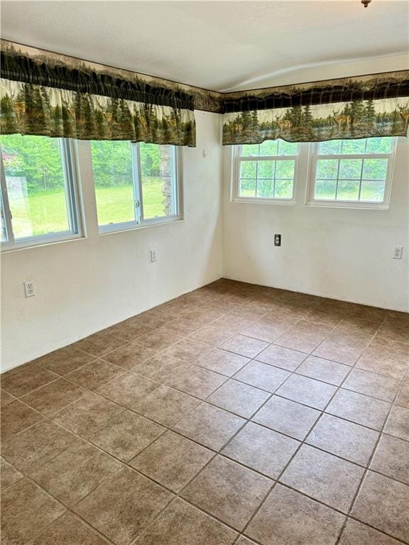 spare room with tile patterned floors and plenty of natural light
