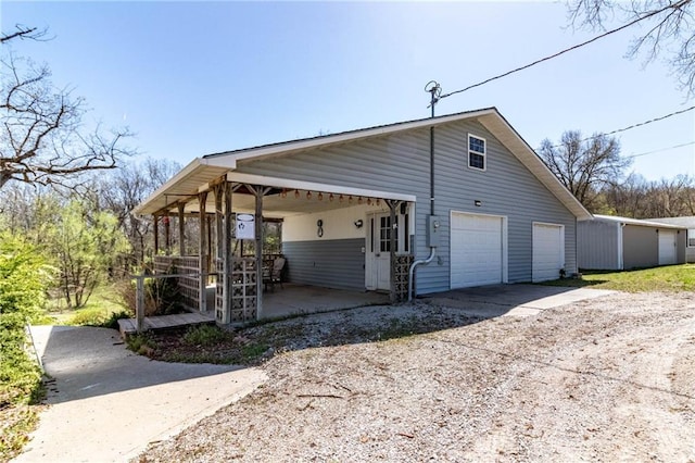 view of side of home featuring a garage and dirt driveway