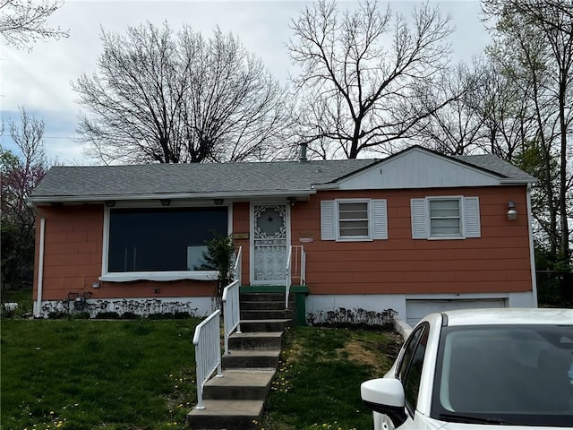 view of front of home featuring a front yard, an attached garage, and roof with shingles