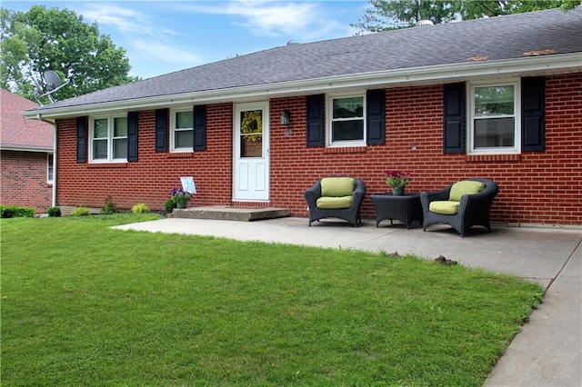 509 W 30th St, Higginsville, MO 64037 - view of front facade featuring a front lawn, brick siding, a shingled roof, and a patio
