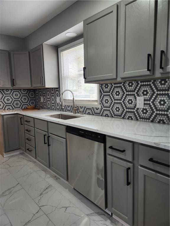 kitchen with gray cabinets, dishwasher, a sink, and marble finish floor