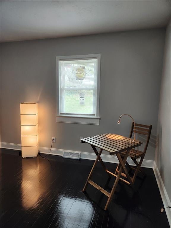 dining space with baseboards, visible vents, and hardwood / wood-style flooring