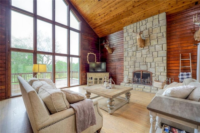43 901st Rd, Clinton, MO 64735 - living room with high vaulted ceiling, a stone fireplace, wood ceiling, wood finished floors, and wood walls