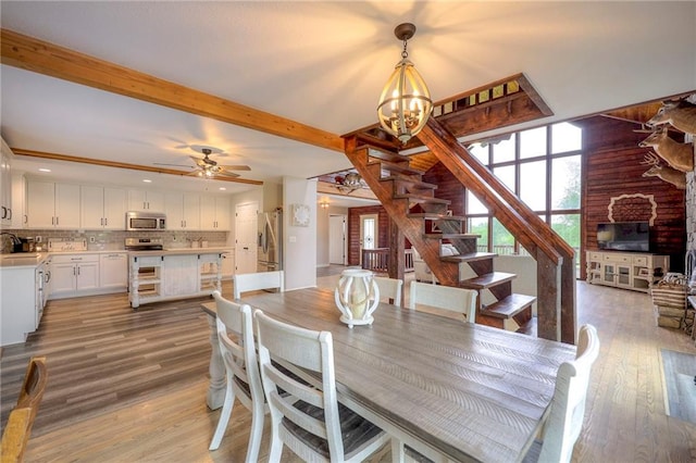 43 901st Rd, Clinton, MO 64735 - dining room with light wood-style floors, ceiling fan with notable chandelier, beamed ceiling, and stairway