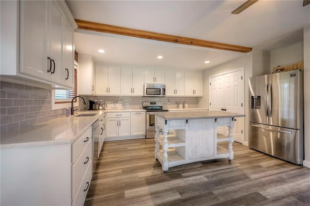 43 901st Rd, Clinton, MO 64735 - kitchen featuring backsplash, white cabinets, stainless steel appliances, a sink, and wood finished floors